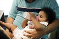 Brizilian father feeding toddler daughter