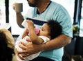 Brizilian father feeding toddler daughter Royalty Free Stock Photo