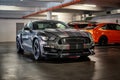 A gray sporty Ford Mustang is parked in a public underground garage
