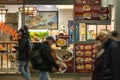 People passing with a speed blur in front of a Vietnamese fast food restaurant serving Asian food.