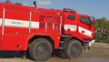 Brno, Czechia - October 08, 2021: Red heavy armoured fire fighting vehicle driving fast over rough road. Demonstration for public