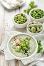 Broad bean soup with fresh mint and feta cheese in a white bowl on a wooden table. Royalty Free Stock Photo