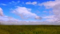 A broad-field landscape and low-flying clouds.