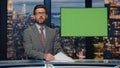 Broadcast presenter reporting daily news at television channel with green screen Royalty Free Stock Photo
