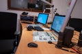 Broadcast studio featuring modern equipment with computers, microphones, and sound controls positioned for live programming Royalty Free Stock Photo
