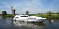 Broads Cruiser on the river Ant Norfolk Boards windmill in background.