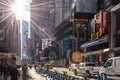 Broadway Avenue in Times Square New York on a Sunny Day. Street Full of Billboards and Advertisements. Sun Flares Through Clouds