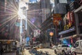 Broadway Avenue in New York Times Square on a Sunny Day. Street Full of Billboards and Advertisements. Sun Flares Through Clouds