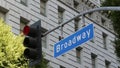 Broadway street name, odonym sign and traffic light on pillar in USA. Road intersection in downtown of city. Crossroad in urban Royalty Free Stock Photo