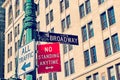 Broadway Street Signs with brick building in soft focus in the b