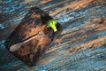 Broccoli on antique fork on burned-out kitchen board on rough dyed wooden table.