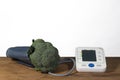 broccoli  and blood pressure meter on a wooden table and white background Royalty Free Stock Photo