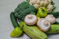 Broccoli and cauliflower with sweet peppers and porcini mushrooms lie on a white table. Two large zucchini Royalty Free Stock Photo