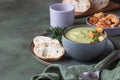 Broccoli cream soup decorated with thyme, cream, roasted cauliflower and fresh bread on green concrete background. Healthy Royalty Free Stock Photo