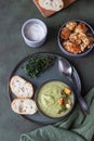 Broccoli cream soup decorated with thyme, cream, roasted cauliflower and fresh bread on green concrete background. Healthy Royalty Free Stock Photo