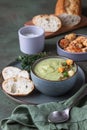 Broccoli cream soup decorated with thyme, cream, roasted cauliflower and fresh bread on green concrete background. Healthy Royalty Free Stock Photo