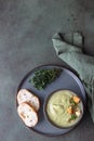 Broccoli cream soup decorated with thyme, cream, roasted cauliflower and fresh bread on green concrete background. Healthy Royalty Free Stock Photo