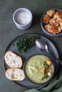 Broccoli cream soup decorated with thyme, cream, roasted cauliflower and fresh bread on green concrete background. Healthy Royalty Free Stock Photo