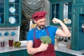 Broccoli gives power to man. bicep or broccoli chose. Guy holds broccoli in hands and shows his bicep. Royalty Free Stock Photo
