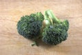 Two small broccoli head on rustic background