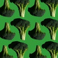 Broccoli pattern on a solid green background. Healthy diet. Colorful and fresh food. Broccoli cabbage. Photographed in harsh light
