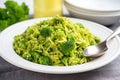 broccoli rice in a white ceramic plate with silver fork