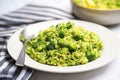 broccoli rice in a white ceramic plate with silver fork