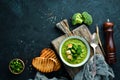 Broccoli, spinach cream soup in a bowl with toasted bread. Green soup. Dietary food.