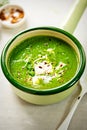 Broccoli spinach pea cream soup with cream and chilli flakes