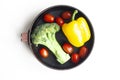 Broccoli, yellow bell pepper and red cherry tomatoes in a round pan