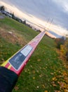 Brocken Red Hockey Stuck Facing Towards a Sunset Behind a Hydro Pole and Autumn Trees