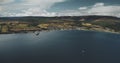 Brodick ocean ferry terminal aerial view: ships, boats and sailboat on ocean bay at Scottish harbor