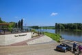 View beyond hotel terrace with outdoor restaurant on people waiting for ferry to arcen over river maas in summer