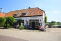 View on old rural tourist hotel at river maas near ferry pier in small dutch village in summer