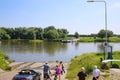 View on people waiting for the passenger, car and bicycle ferry over river maas to arcen in summer