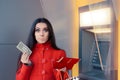 Broke Woman Holding One Dollar in Front of an ATM Royalty Free Stock Photo