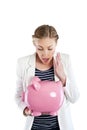 Broke woman holding a piggy bank against a white background