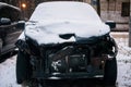 Broken, abandoned car covered with a layer of snow in the Parking lot in the city Park Royalty Free Stock Photo