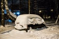 Broken, abandoned car covered with a layer of snow in the Parking lot in the city Park Royalty Free Stock Photo