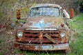 Broken abandoned rusty old truck left on a rural field