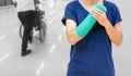 broken arm with green cast and arm sling on blurred bac Royalty Free Stock Photo