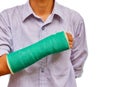 Broken arm with green cast on white background