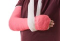 Broken arm in red plaster cast and sling Royalty Free Stock Photo