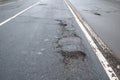 Broken asphalt road in city and untimely repair. Pothole asphalt road. Roadway in bad condition Royalty Free Stock Photo