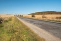 Broken asphalt road through the field at sunny day Royalty Free Stock Photo