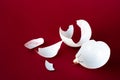 Broken ball decoration of a Christmas tree. White shards on a red background. Copy space Royalty Free Stock Photo