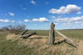 A broken barbed wire fence with old rustic wooden posts