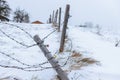 Broken barbed wire fence in the snow