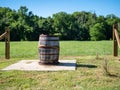 Almost broken barrel sitting in front of field on sunny day