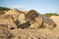 Broken big heavy bucket lies on sand on summer day